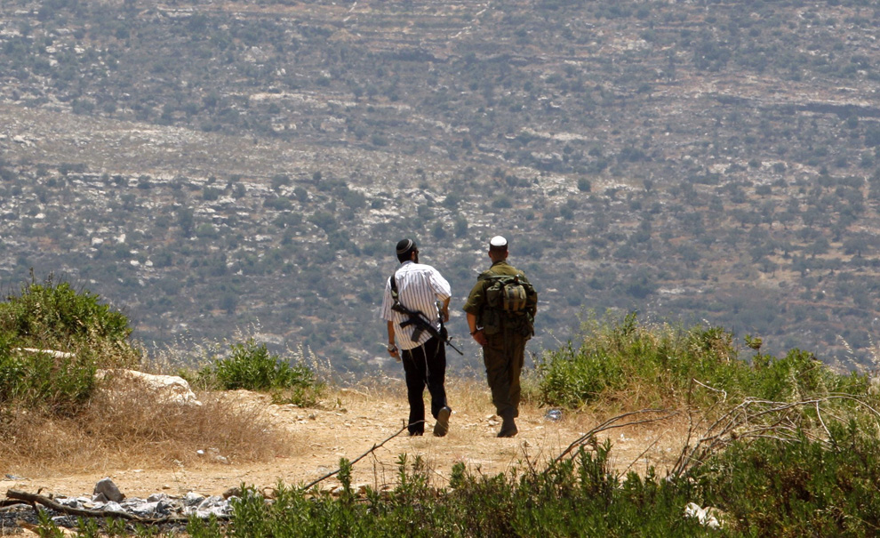 Pemukim Yahudi dan tentara Israel berpatroli di desa sepanjang Horch, terletak di Tepi Barat dekat Ramallah.  Gambar diambil 14 Juni 2009.  (REUTERS / Gil Cohen Magen)