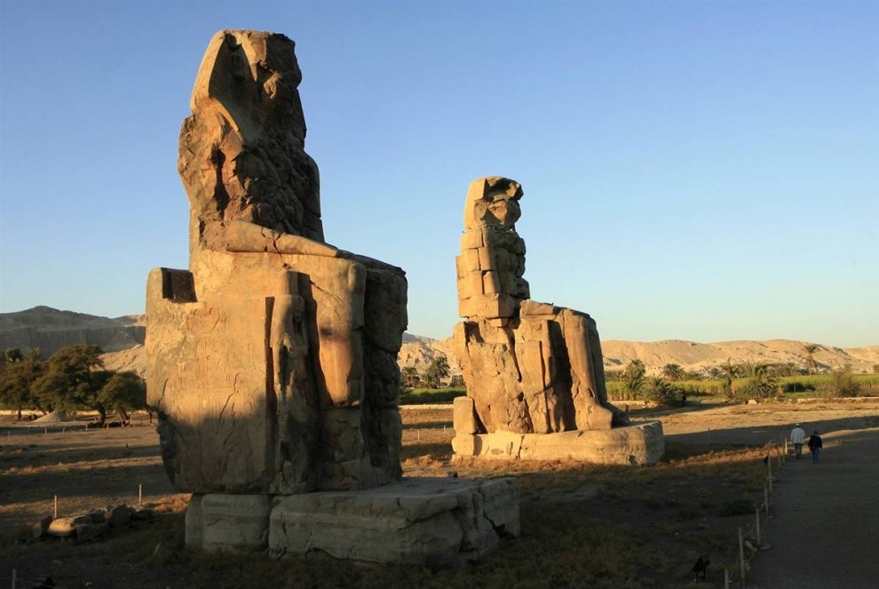 16) Туристы осматривают Колоссы Мемнона – 2 огромные каменные статуи фараона Имхотепа III. Статуи-близнецы расположены в Фиванском некрополе на противоположном от Луксора берегу Нила. (Khaled Desouki/AFP - Getty Images)