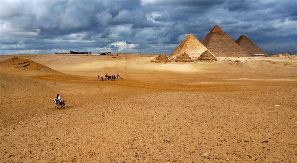 1) Туристы верхом на лошадях и верблюдах осматривают исторический памятник - пирамиды Гизы, находящиеся недалеко от Каира. Пирамиды являются единственным из древних семи чудес света, сохранившимся до наших дней. Кроме того, они вошли в список новых семи чудес света, составленный в 2008 году. (Muhammed Muheisen/AP)
