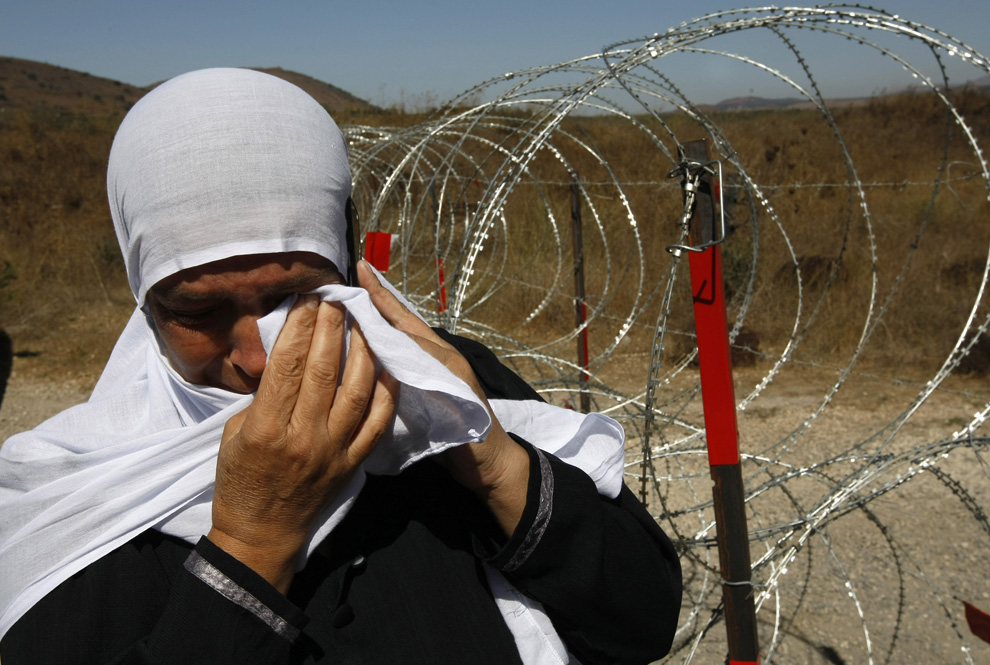 8) Satu Arin Safadi kerabat menangis berdiri di perbatasan antara Israel dan Suriah September 25, 2008.  (Menahem Kahana / AFP / Getty Images)