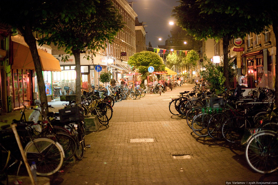 25) Типичная улица, все обочины заставлены велосипедами.