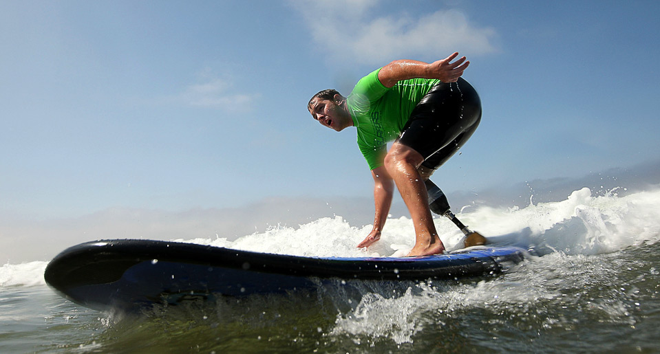 11) Серфер с ампутированной конечностью Райан Уэст плывет по волнам 15 августа. (Ezra Shaw/Getty Images)
