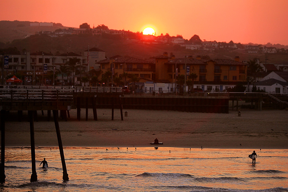 7) Местные серферы заходят в волны на закате перед началом события «Operation Restoration IV» 14 августа. (Ezra Shaw/Getty Images)