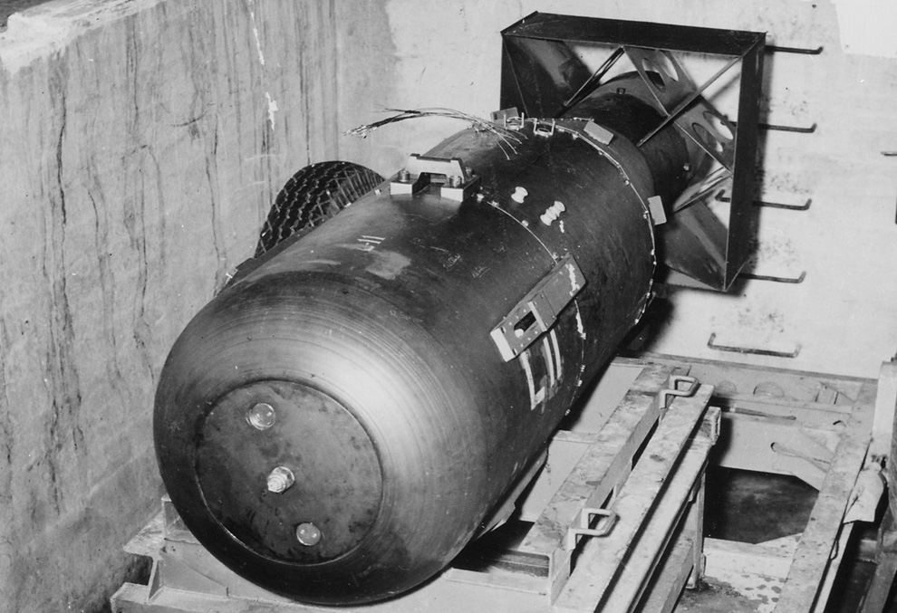 6. «Малыш» покоится на трейлере в яме над шлюзом бомбардировщика B-29 Superfortress "Enola Gay" на базе 509-ой сводной группы на Марианских островах в 1945 году. «Малыш» составлял 3 м в длину и весил 4 000 кг, но содержал всего 64 кг урана, который использовался для провоцирования цепочки атомных реакций и последующего взрыва. (U.S. National Archives)
