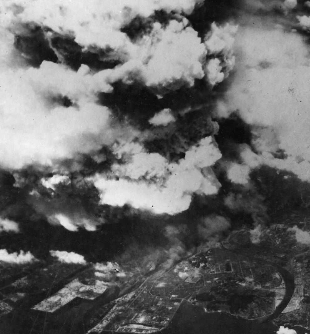 7. Фото, сделанное из одного из двух американских бомбардировщиков 509-ой сводной группы, вскоре после 8:15, 5 августа 1945 года, показывает поднимающийся от взрыва дым над городом Хиросима. К моменту съемки уже произошла вспышка света и жара от огненного шара диаметром 370 м, и взрывная волна, движущаяся со скоростью света, быстро рассеивалась, уже причинив основной вред зданиям и людям в радиусе 3,2 км. (U.S. National Archives)