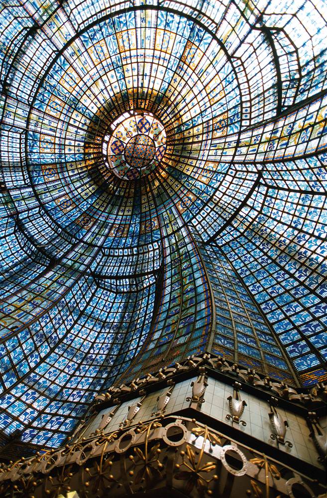 22) Глядя в стекло: Изысканный купол из цветного стекла внутри универмага «Magasins du Printemps» находится над главным рестораном торгового центра. Установленный в 1932 году, он состоит из 3 185 отдельных кусочков цветного стекла. (David Lefranc/Paris Tourist Office)