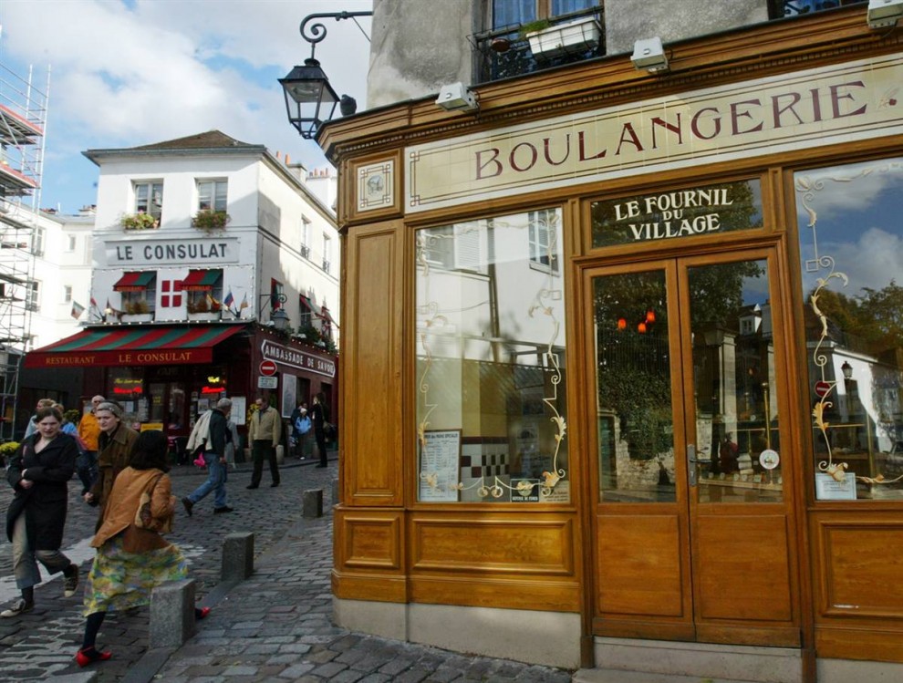 10) Перерыв на чашечку кофе: Люди проходят мимо пекарни в районе Монмартр в Париже. (Michel Euler/AP)