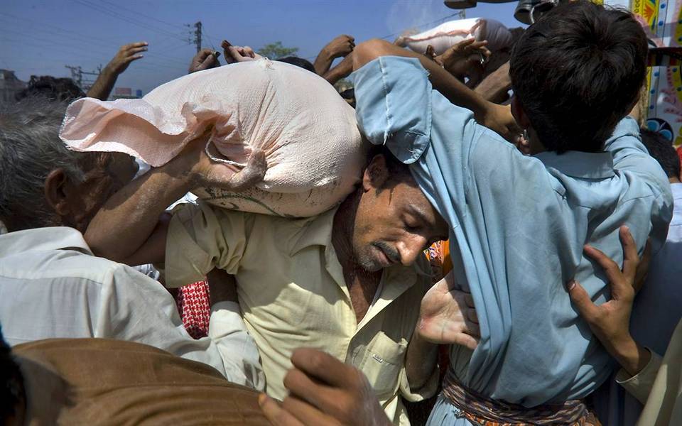 7.  Pakistan membawa sekarung tepung, dibeli dengan uang yang diterima dari Pemerintah, selama bulan suci Ramadhan, di Rawalpindi, Pakistan.  (Anjum Naveed / AP)