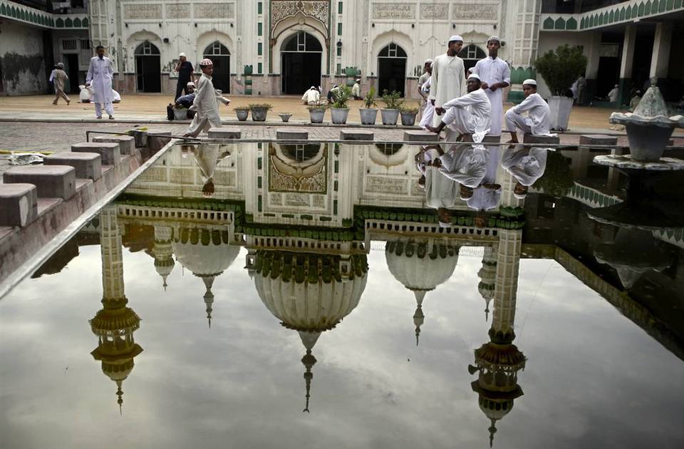 9.  Muslim yang duduk di samping kolam di Masjidil Haram setelah salat Jumat di Amritsar, India.  (Altaf Qadri / AP)