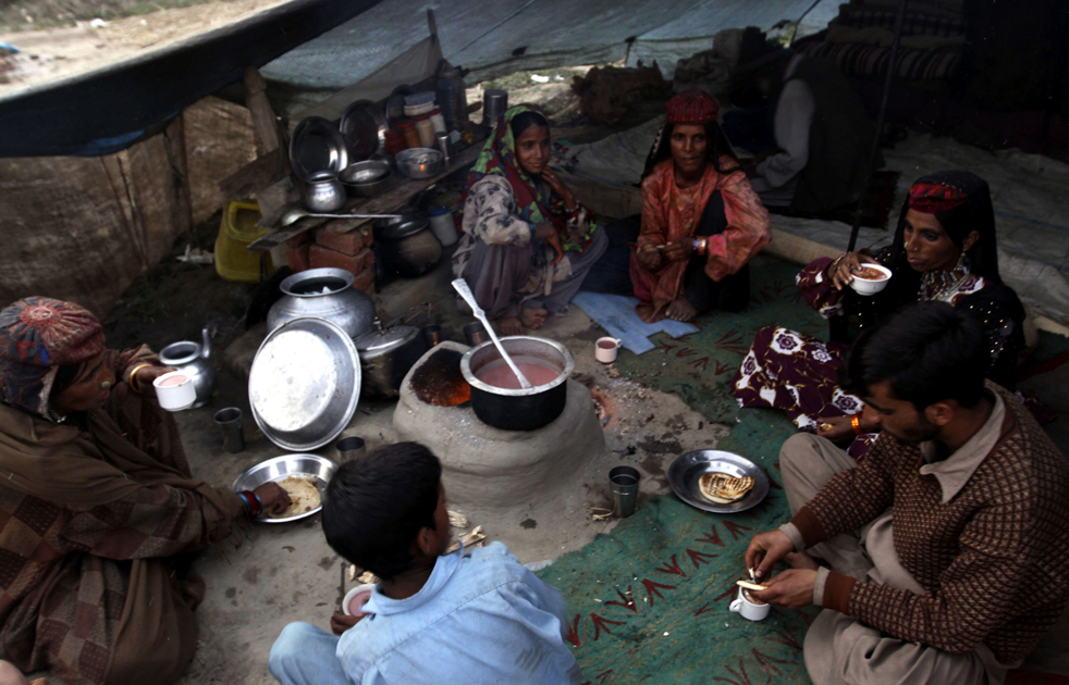 18.  Kashmir keluarga nomaden bakarval minum teh asin masyarakat di kamp sementara di pinggiran kota Srinagar India (AP / Dar Yasin)