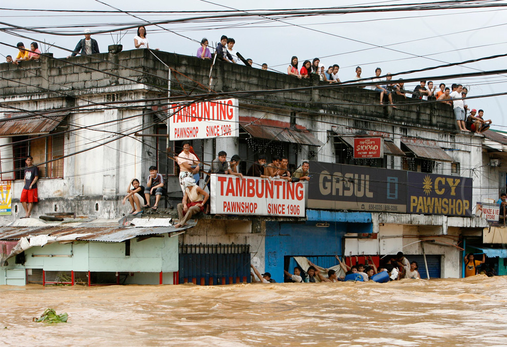 4. Жители Каинта Ризал в ожидании спасателей на крыше здания во время наводнения, вызванного тайфуном Кетсана к востоку от Манилы 27 сентября 2009 года. (REUTERS/Erik de Castro)