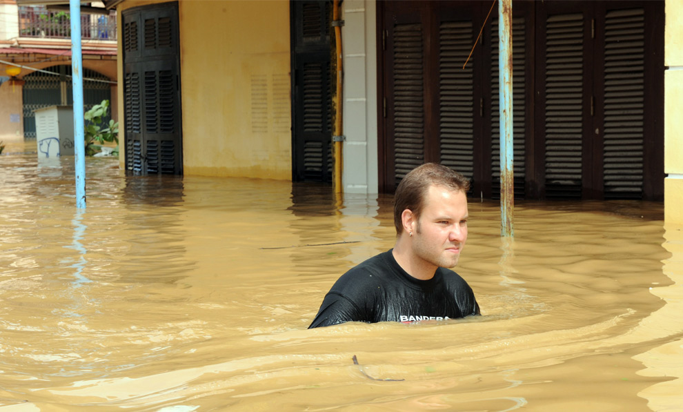 7. Турист идет вброд по затопленной улице в городе Хои Ан в центральной Вьетнамской провинции Куангнам 30 сентября 2009 года. (HOANG DINH NAM/AFP/Getty Images)