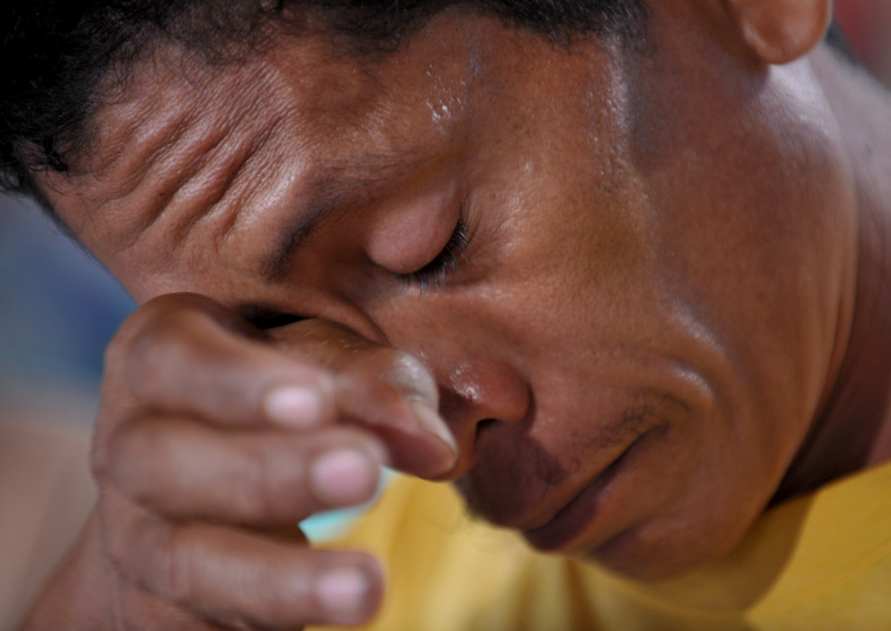 13. 40-летний Дэнни Веласко плачет у гроба с телом своей жены Розалии и двоих детей, которые погибли в наводнении в Маниле в выходные 28 сентября 2009 года. (JAY DIRECTO/AFP/Getty Images)
