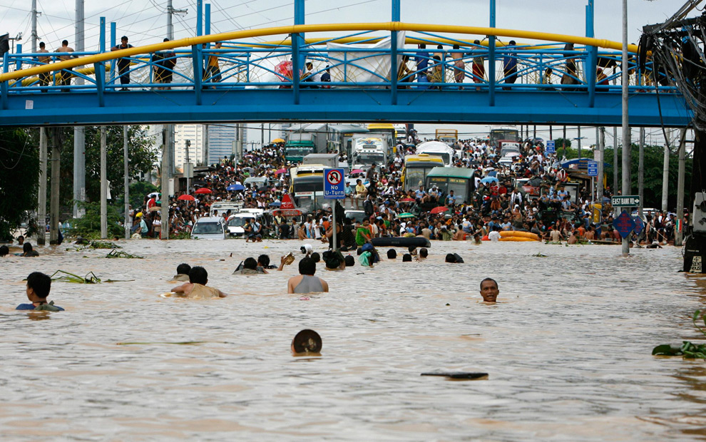 14. Жители плывут к возвышенности в Каинта Ризал к востоку от Манилы 27 сентября 2009 года. (REUTERS/Erik de Castro)