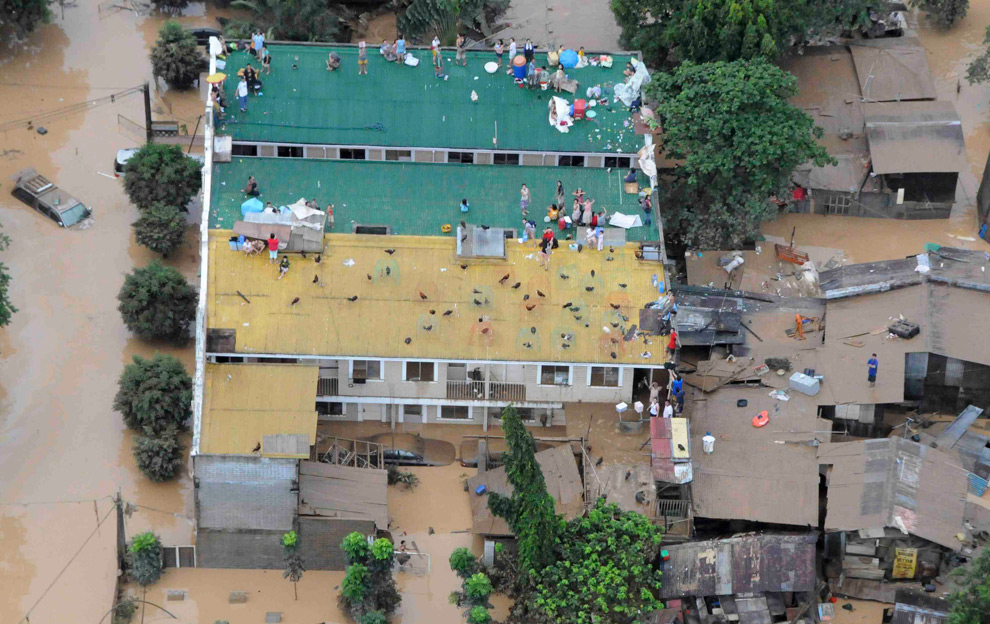 17. На этом снимке, сделанном с воздуха филиппинскими военно-воздушными силами, можно на крыше увидеть жителей города Марикина, спасающихся от наводнения после тайфуна Кетсана 27 сентября 2009 года. (REUTERS/Rey Bruna/Philippines Airforce/Handout)