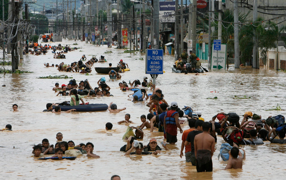18. Жители идут вброд после шторма Кетсана в Каинта Ризал к востоку от Манилы 27 сентября 2009 года. (REUTERS/Erik de Castro)