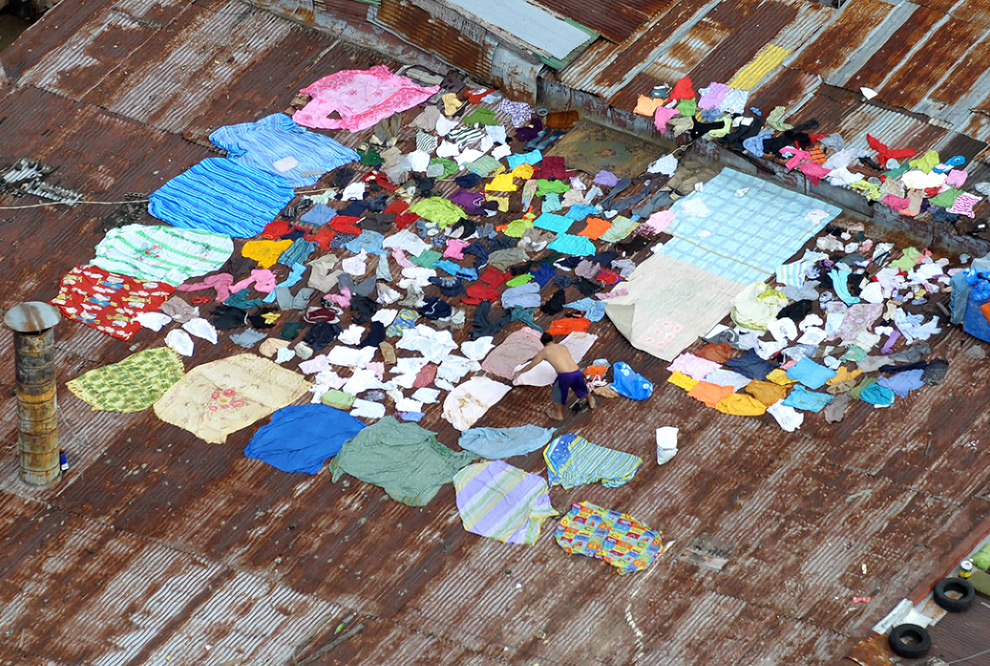 24. Мужчина сушит одеяла и одежду на крыше в городе Ангоно к востоку от Манилы 29 сентября 2009 года, который спустя три дня после тропического шторма Кетсана все еще затоплен водой. (JAY DIRECTO/AFP/Getty Images)