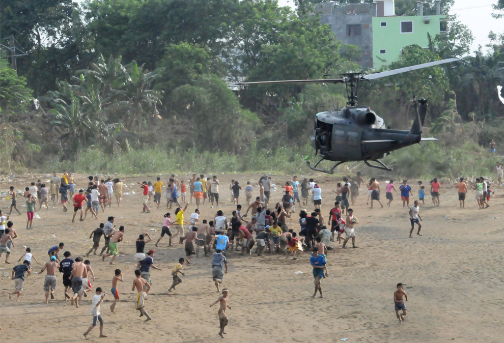 26. Жертвы наводнения бегут к вертолету, который сбрасывает им провизию в поселке Сан Матео в провинции Ризал к востоку от Манилы, Филиппины, во вторник 29 сентября 2009 года. (AP Photo/Philippine Air Force, Rogel Vidallo)