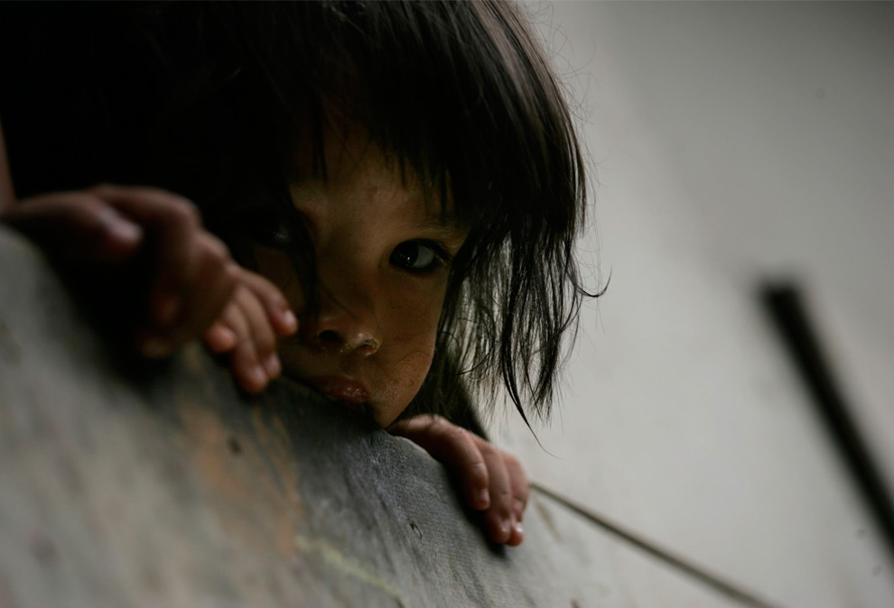 29. Девочка выглядывает со второго этажа дома в восточной Маниле, Филиппины, во вторник 29 сентября 2009 года. (AP Photo/Wally Santana)