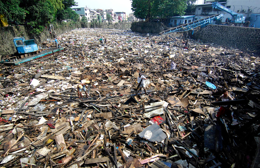 31. Рабочие расчищают реку, заполненную обломками от уничтоженных домов после тайфуна Кетсана в Маниле 30 сентября 2009 года. (NOEL CELIS/AFP/Getty Images)