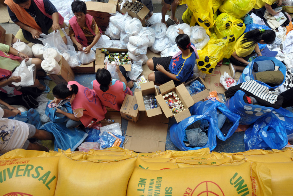 34. Добровольцы упаковывают предметы первой необходимости в небольшие мешки внутри здания школы в Маниле 30 сентября 2009 года, чтобы доставить их жертвам наводнения. Международное сообщество помогло Маниле справиться с гуманитарным кризисом, последовавшим за штормом Кетсана, и оставившим без домов 375 тысяч человек. (JAY DIRECTO/AFP/Getty Images)