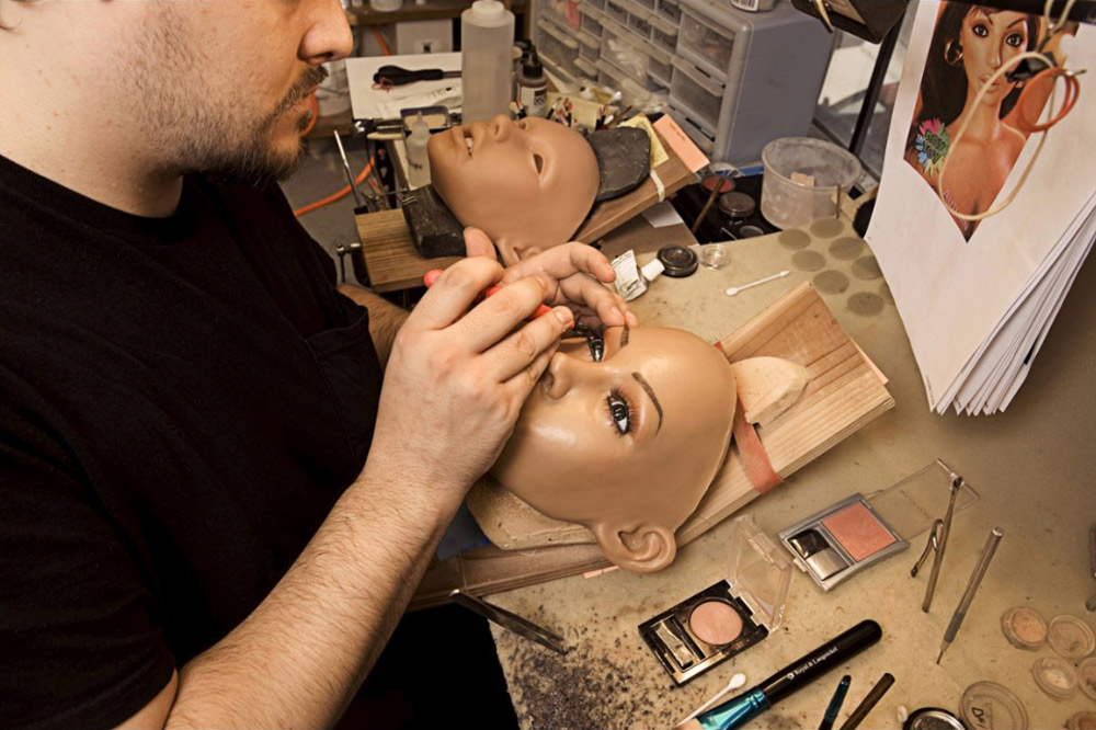 6. Стилист Дерек Транк, работающий в компании уже два года, красит кукле глаза. Он говорит, что на создание лица уходит около недели. Зубы и десны также делаются из силикона. (Stephan Gladieu/Getty Images)