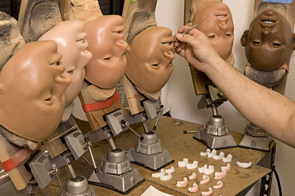 8. Дерек Транк в процессе нанесения косметики на лицо куклы. (Stephan Gladieu/Getty Images)