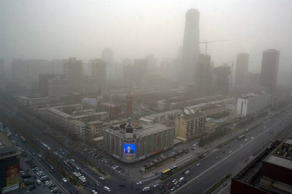 15. Пекин известен своим постоянным загрязнением окружающей среды, нависшим над столицей Китая. Попытки снизить выбросы дыма, сделав автомобили чище, произвели второстепенный эффект на снижение выброса парниковых газов. (Ng Han Guan / AP)
