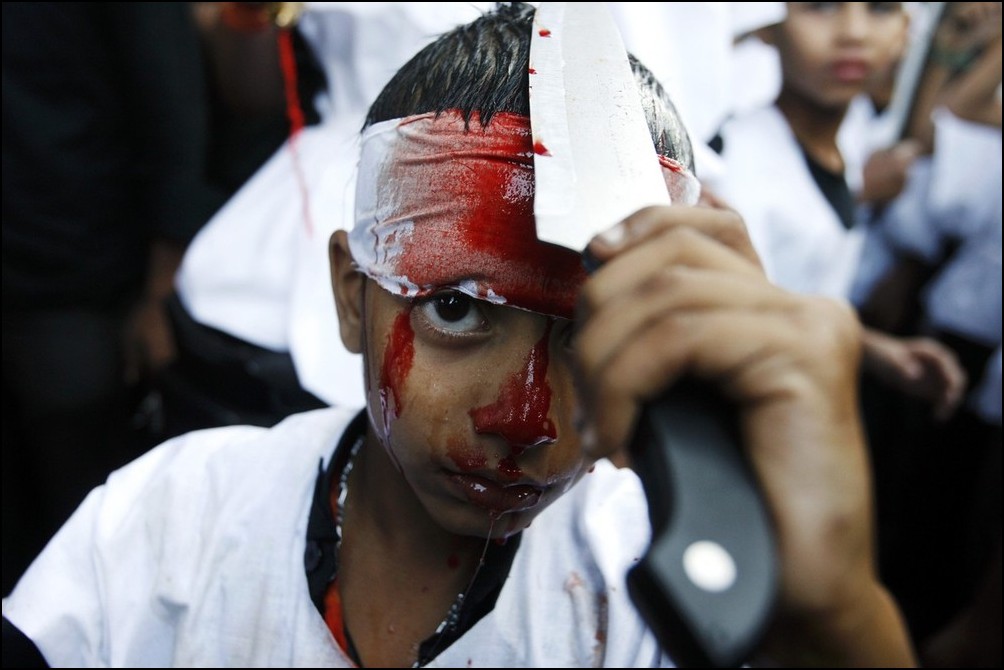 2) © Reuters / Arko Datta / / anak laki-laki memotong dirinya sendiri dengan pisau selama festival Asyura.