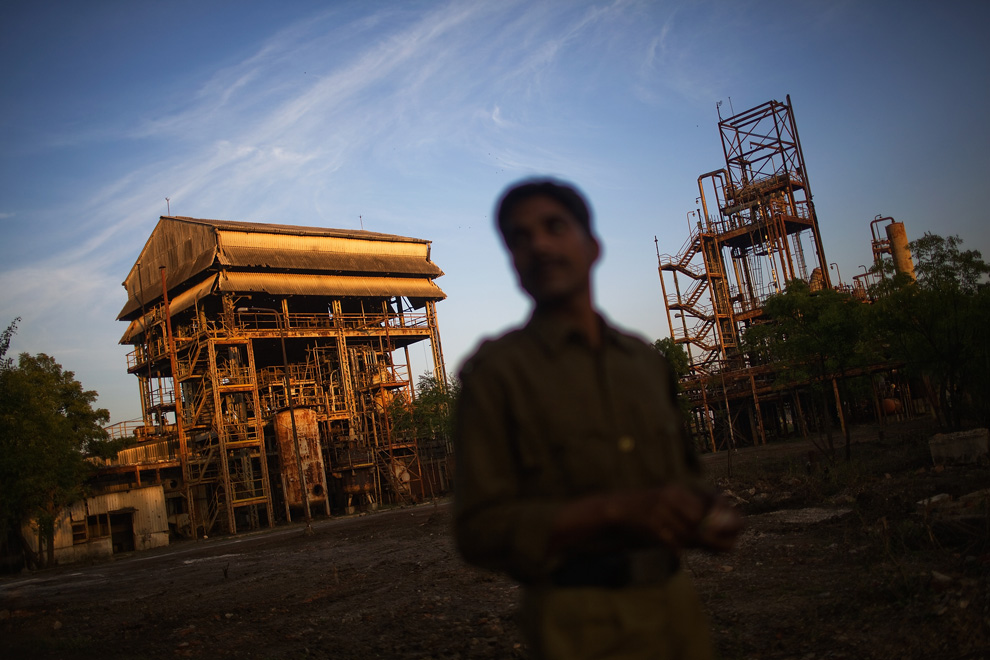 14. Полицейский осматривает заброшенный завод «Union Carbide» 28 ноября 2009 года в Бхопале, Индия. (Daniel Berehulak/Getty Images)