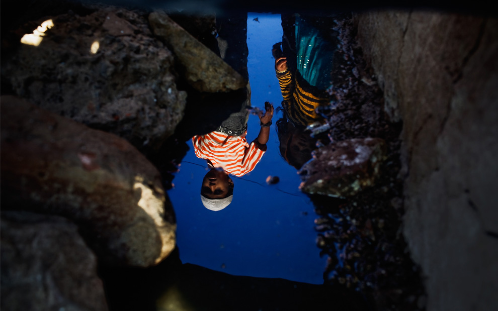 19.  Anak-anak tercermin dalam air tanah yang terkontaminasi dekat pabrik kosong «Union Carbide» November 28, 2009 di Bhopal, India.  (Daniel Berehulak / Getty Images)