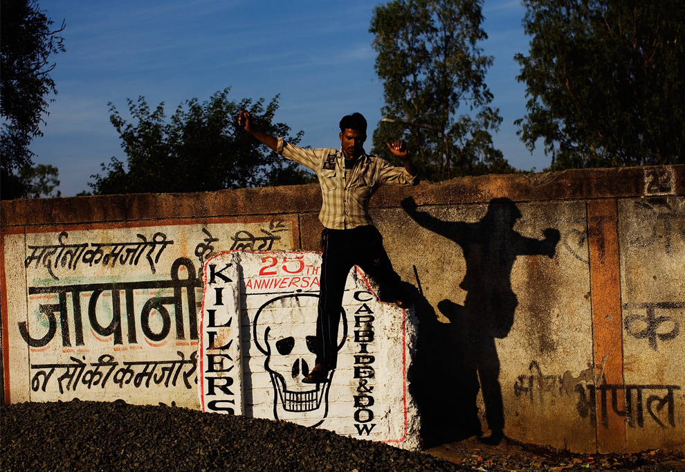 26. Мужчина спрыгивает с периметровой стены на территории завода «Union Carbide» 28 ноября 2009 года в Бхопале, Индия. (Daniel Berehulak/Getty Images)