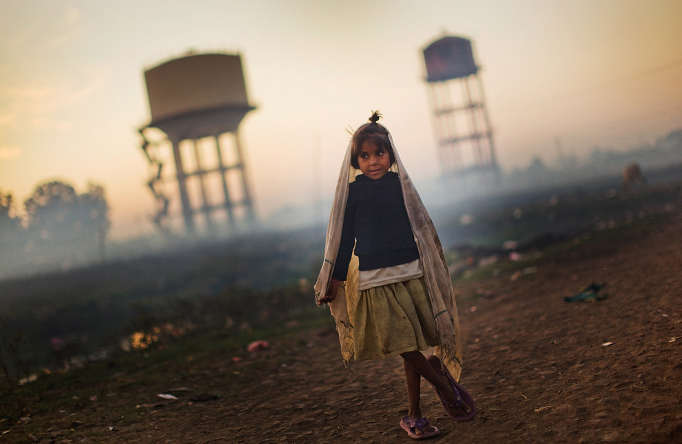 28.  Seorang gadis berdiri di samping menara air di dekat rumahnya di dekat pabrik «Union Carbide» November 27, 2009 di Bhopal, India.  (Daniel Berehulak / Getty Images)