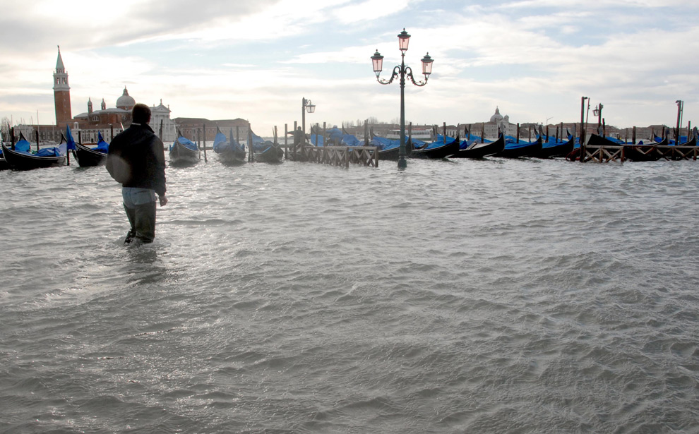 12. Молодой человек идет по затопленному причалу Венеции 1 декабря 2008 года. (ANDREA PATTARO/AFP PHOTO/AFP/Getty Images)