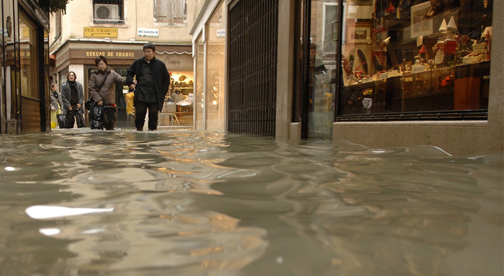 13. Туристы идут вброд по затопленным улицам торгового района Венеции 1 декабря 2008 года. (REUTERS/Michele Crosera)