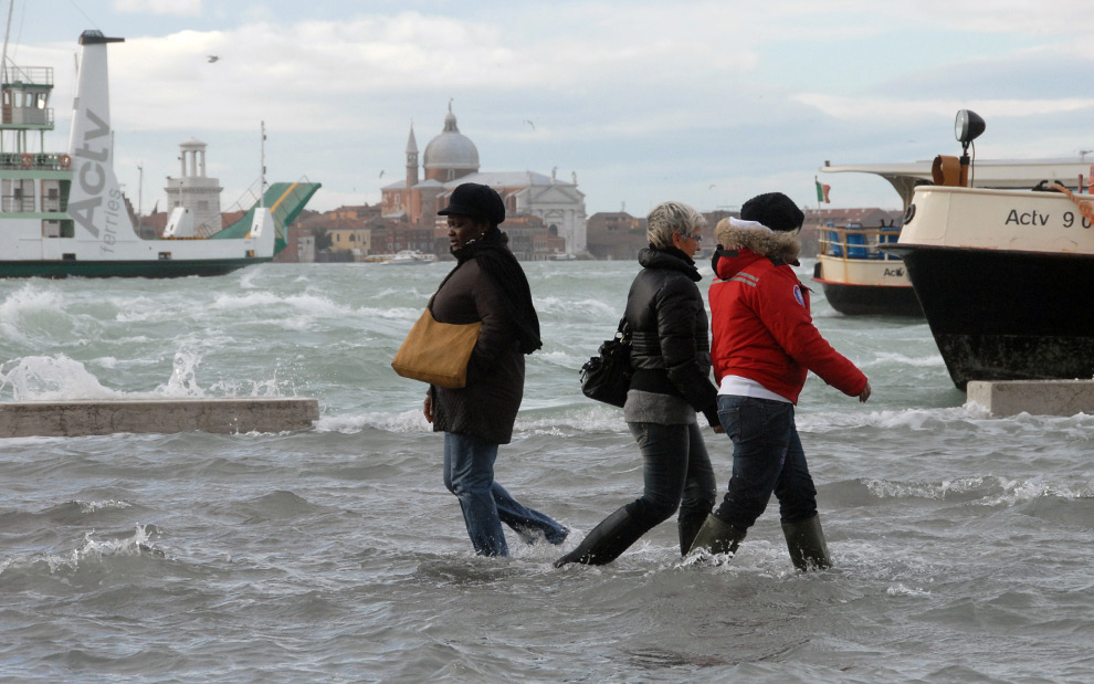 15. Люди идут по затопленной прибрежной дорожке Венеции 1 декабря 2008 года. (ANDREA PATTARO/AFP PHOTO/AFP/Getty Images)