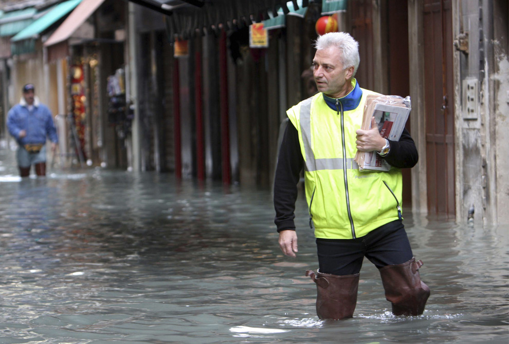 18. Полицейский несет конверты и документы по затопленной улице в Венеции 1 декабря 2008 года. (REUTERS/Manuel Silvestri)