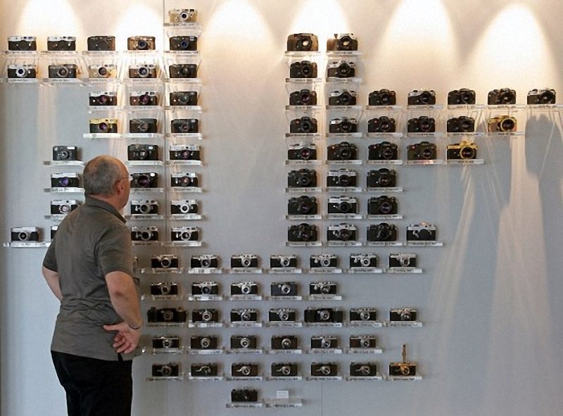 11) Ральф Хагенауэр(Ralph Hagenauer), глава департамента по распространению продукции компании Leica, рассматривает модельный ряд камер, в вестибюле центрального офиса.