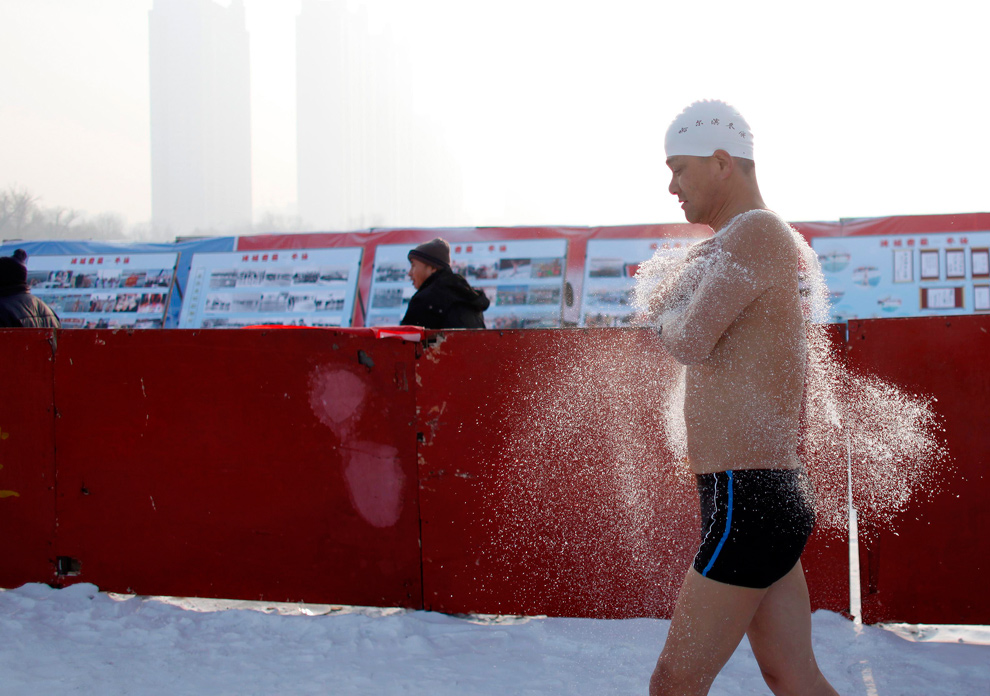 6. «Морж» разогревается перед прыжком в холодные воды реки Сунхуа в Харбине 4 января 2010 года. (REUTERS/Aly Song)
