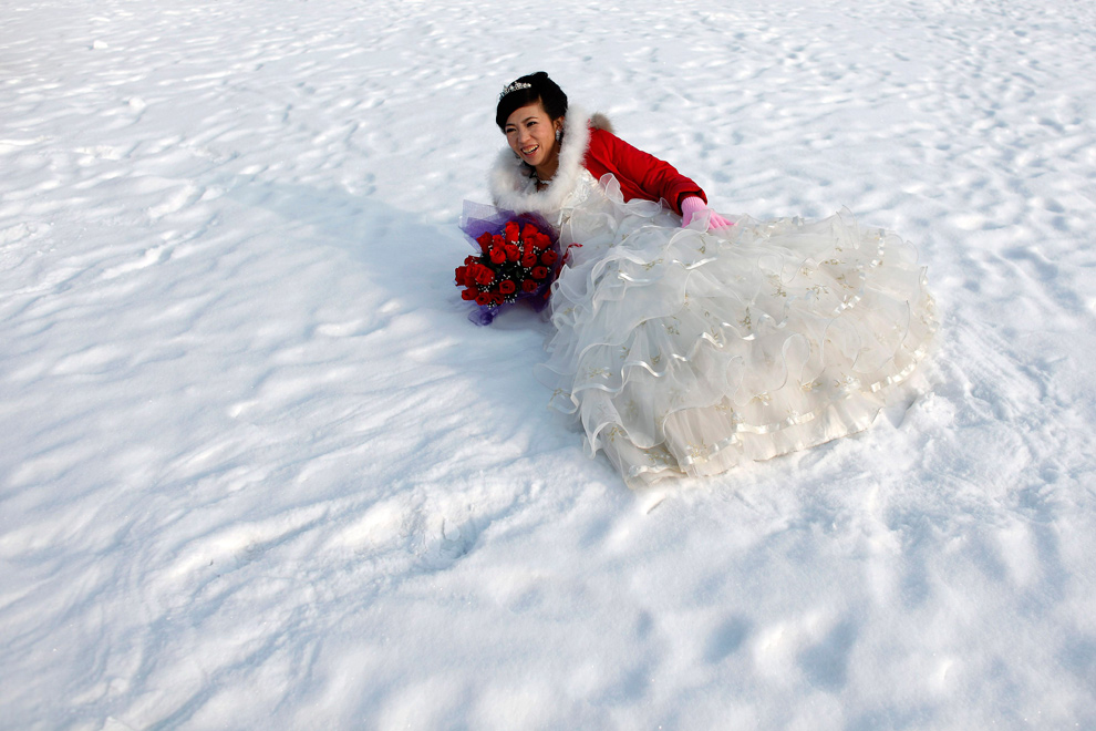 9. Невеста позирует для фотографии после свадебной церемонии на 26-ом Международном фестивале снега и льда в Харбине, провинция Хэйлунцзян, Китай, 6 января 2010 года. (REUTERS/Aly Song)