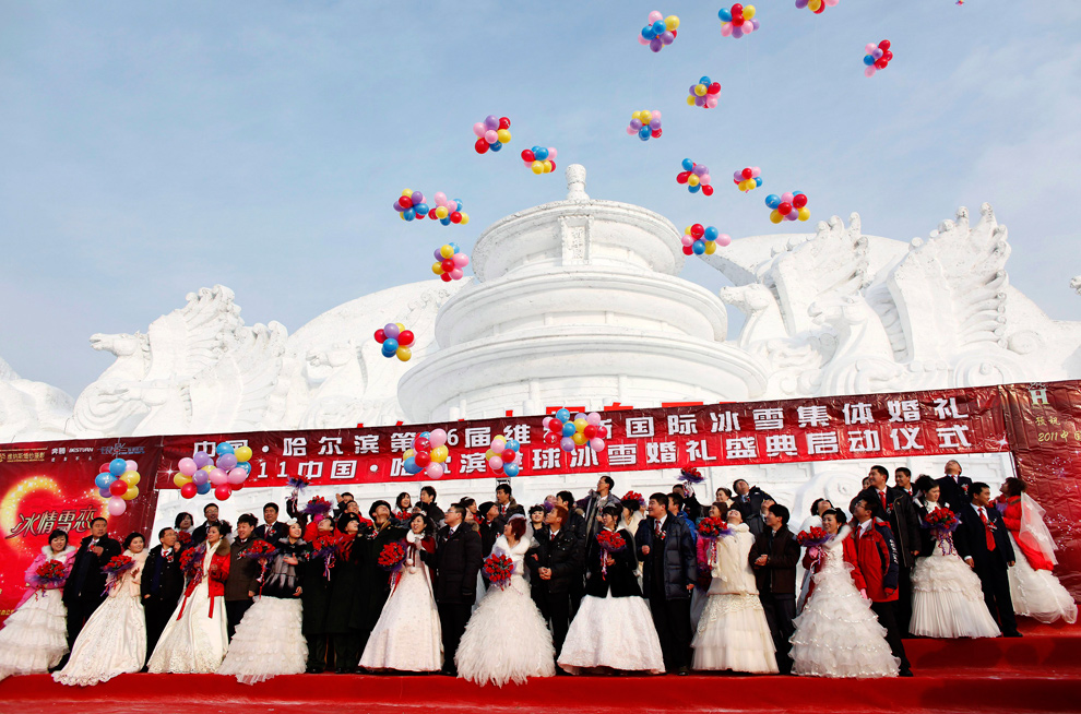 10. Пары принимают участие в групповой свадебной церемонии перед изображением Пекинского Храма Небес из снега 6 января 2010 года. Свадьба была организована правительством, и в церемонии приняли участие 28 пар, на которой присутствовали представители местных органов самоуправления. (REUTERS/Aly Song)