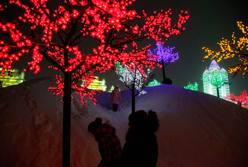 14. Девочка стоит среди ярко освещенных деревьев на Международном фестивале снега и льда в Харбине 6 января 2010 года. (AP Photo/Ng Han Guan)