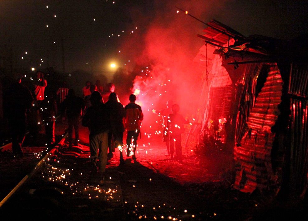 11. Молодежь празднует Новый Год фейерверками и петардами в трущобах Кибера в Найроби, Кения, 1 января 2010 года. (REUTERS/Noor Khamis)