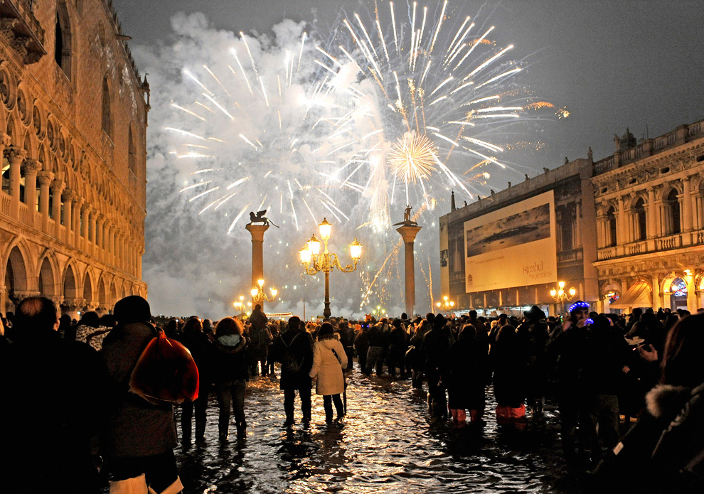 15. Люди смотрят на новогодний салют над площадью святого Марка в Венеции утром в пятницу 1 января 2010 года. (AP Photo/Luigi Costantini)