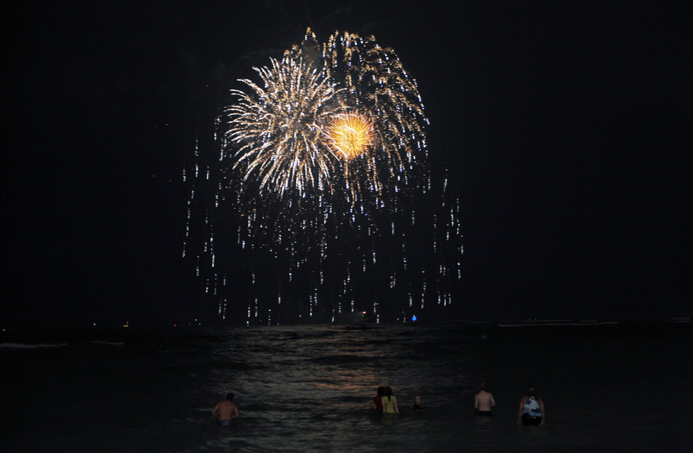 26. Огни фейерверка в небе. Снимок сделан с пляжа Ваикики в Гонолулу, Гавайи, 1 января 2010 года вскоре после того, как часы пробили двенадцать, знаменуя приход нового года. (JEWEL SAMAD/AFP/Getty Images)