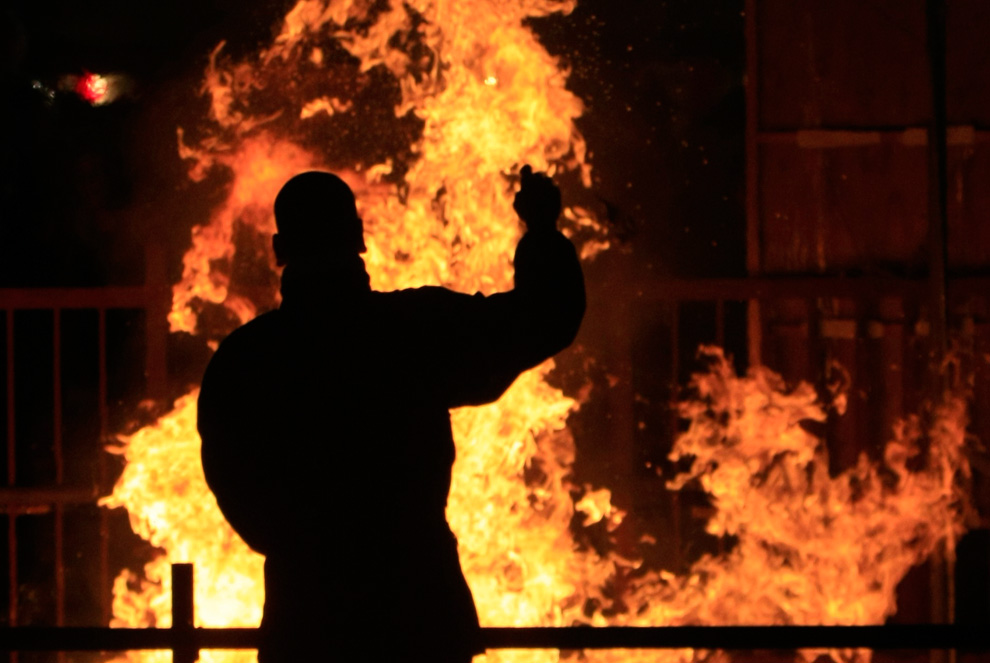 28. Монах стоит перед огнем, в котором горят старые предметы, использовавшиеся в храмах. Снимок сделан во время празднования Нового года в буддистском храме Zojo-ji в Токио 31 декабря 2009 года. (REUTERS/Kim Kyung-Hoon)