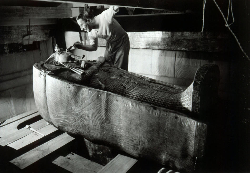 1. <br
/>Археолог Говард Картер смахивает пыль с гробницы с мумией фараона
<br />Тутанхамона. (Harry Burton)