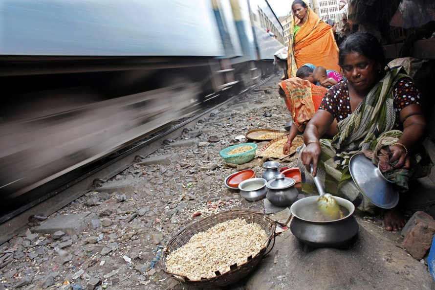 Женщина готовит еду на самодельной плите в трущобах, у железнодорожных путей в Даке, 24 июня 2010 года