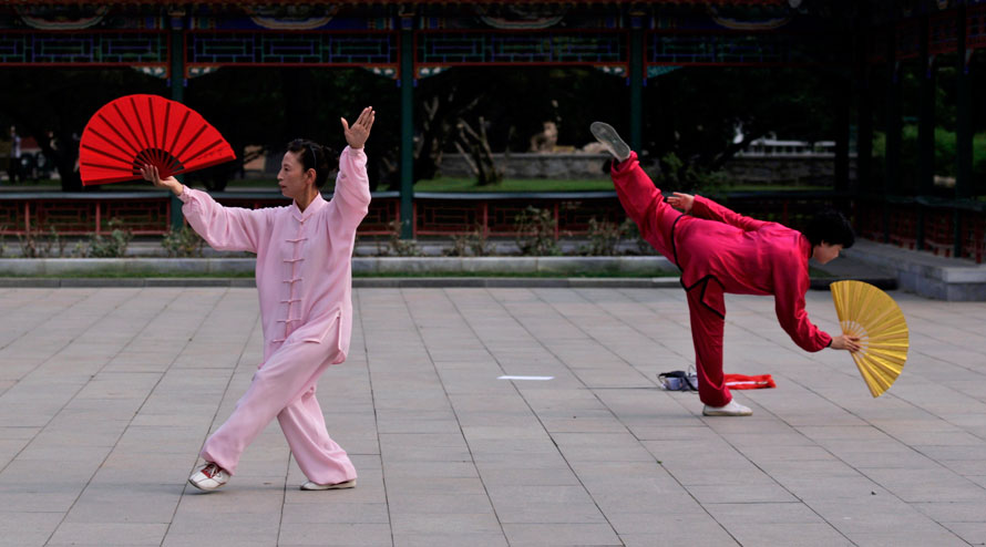 Китаянки отрабатывают приемы тай-чи перед выступлением в Пекине