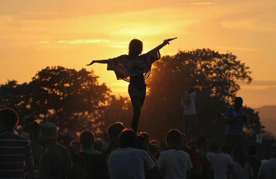 Первые из 140-тысячной армии музыкальных фанатов отрываются на ежегодном фестивале в Гластонбери и наслаждаются закатом на Worthy Farm в городе Пилтон, Гластонбери, Англия, 23 июня 2010 года